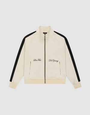 The LFDY Striped Track Jacket by LIVE FAST DIE YOUNG is a cream zip-up with raglan sleeves, black sleeve stripes, gold front pocket zippers, and "Live Fast" and "Die Young" embroidered in black on the chest. | plain