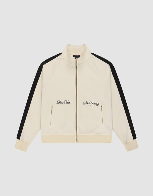 The LFDY Striped Track Jacket by LIVE FAST DIE YOUNG is a cream zip-up with raglan sleeves, black sleeve stripes, gold front pocket zippers, and "Live Fast" and "Die Young" embroidered in black on the chest. | plain