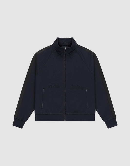 The LFDY Striped Track Jacket by LIVE FAST DIE YOUNG features a navy zip-up design with raglan sleeves, black side stripes, two front zip pockets, and subtle chest embroidery, laid flat on a light gray background. | plain