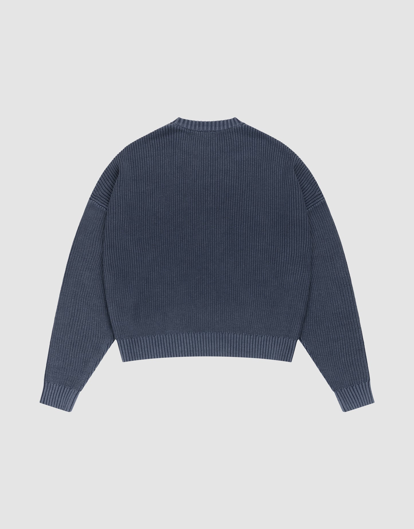 The LFDY Knit Sweater by LIVE FAST DIE YOUNG is shown laid flat from the back. This blue oversized ribbed knit features long sleeves with dropped shoulders, a round neckline, and a straight hem.
