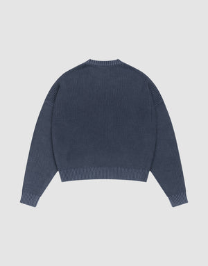 The LFDY Knit Sweater by LIVE FAST DIE YOUNG is shown laid flat from the back. This blue oversized ribbed knit features long sleeves with dropped shoulders, a round neckline, and a straight hem. | plain