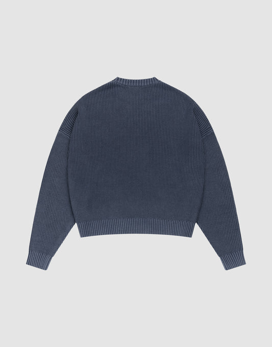 The LFDY Knit Sweater by LIVE FAST DIE YOUNG is shown laid flat from the back. This blue oversized ribbed knit features long sleeves with dropped shoulders, a round neckline, and a straight hem. | plain