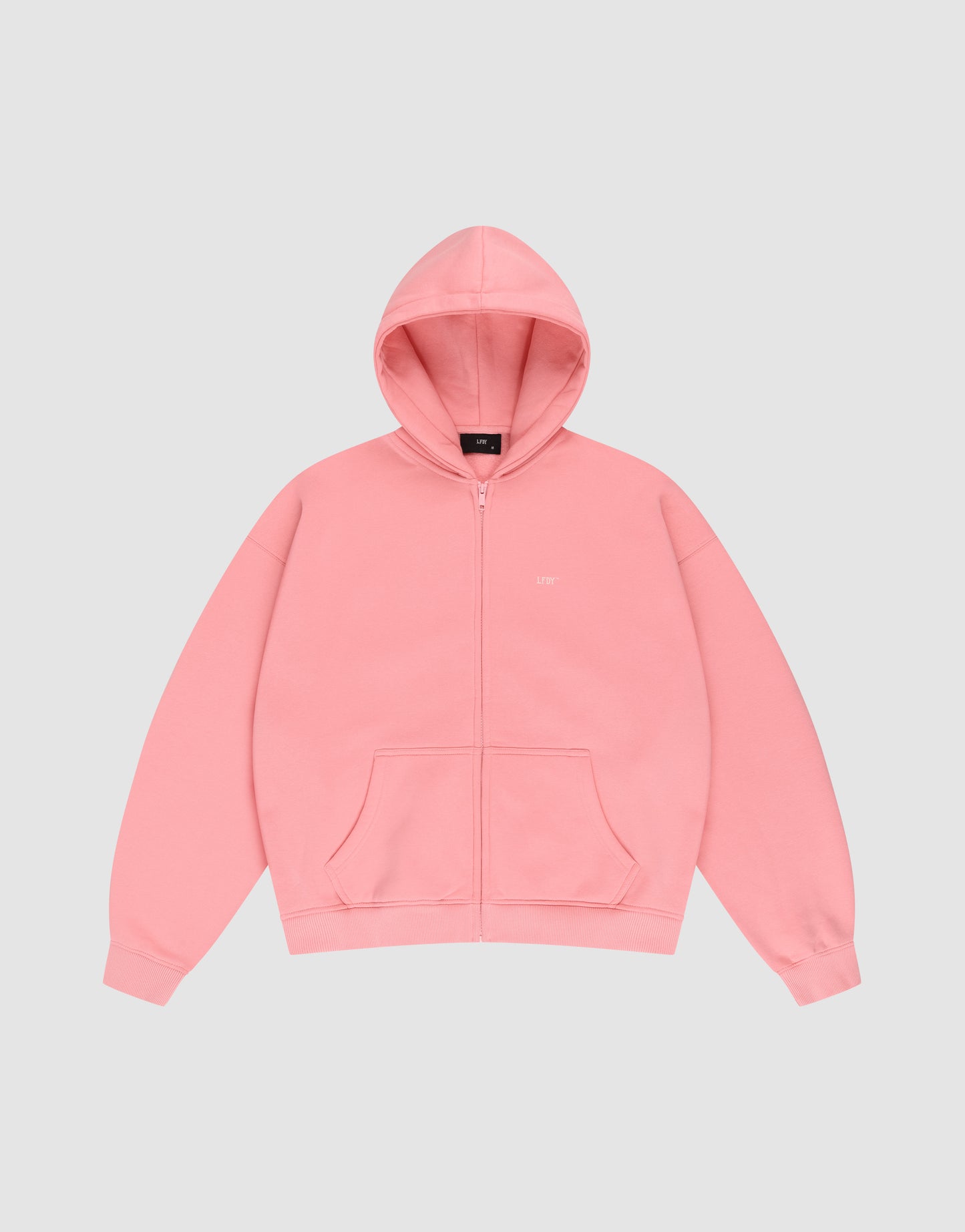 A pink LIVE FAST DIE YOUNG Basic Hooded Zip with logo print, front pocket, and drawstring hood in an oversize fit, shown on a plain light gray background.