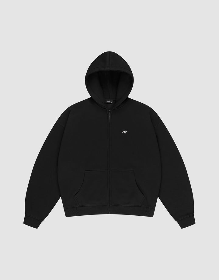 The LIVE FAST DIE YOUNG Basic Hooded Zip is a plain black zip-up hoodie with a hood, front pockets, an oversize fit, and a small white LIFT logo on the left chest, shown laid flat on a light gray background. | plain