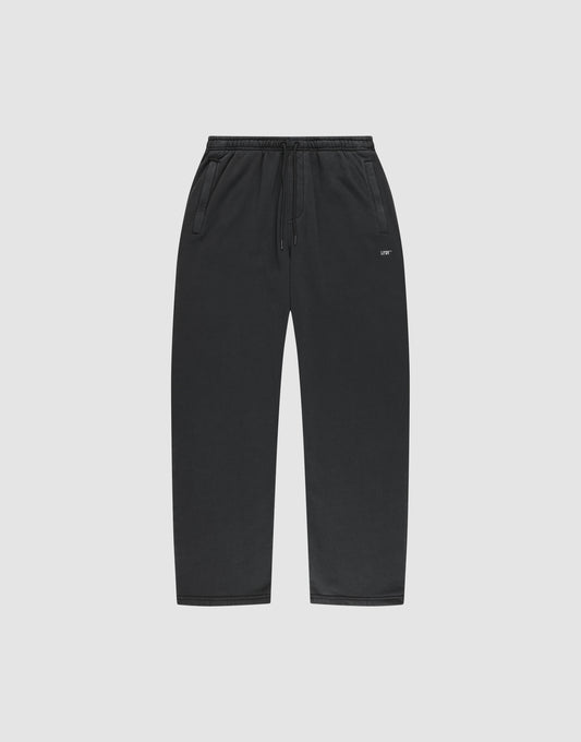 LIVE FAST DIE YOUNG Basic Wide Jogger: black sweatpants with drawstring waist, side pockets, wide fit, and a small white logo on the left thigh. Shown on a plain light gray background. | plain