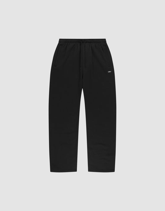 The LIVE FAST DIE YOUNG Basic Wide Jogger features black straight-leg sweatpants with an elastic waistband, drawstring, side pockets, and a small white logo print near the left pocket, shown on a plain light gray background. | plain