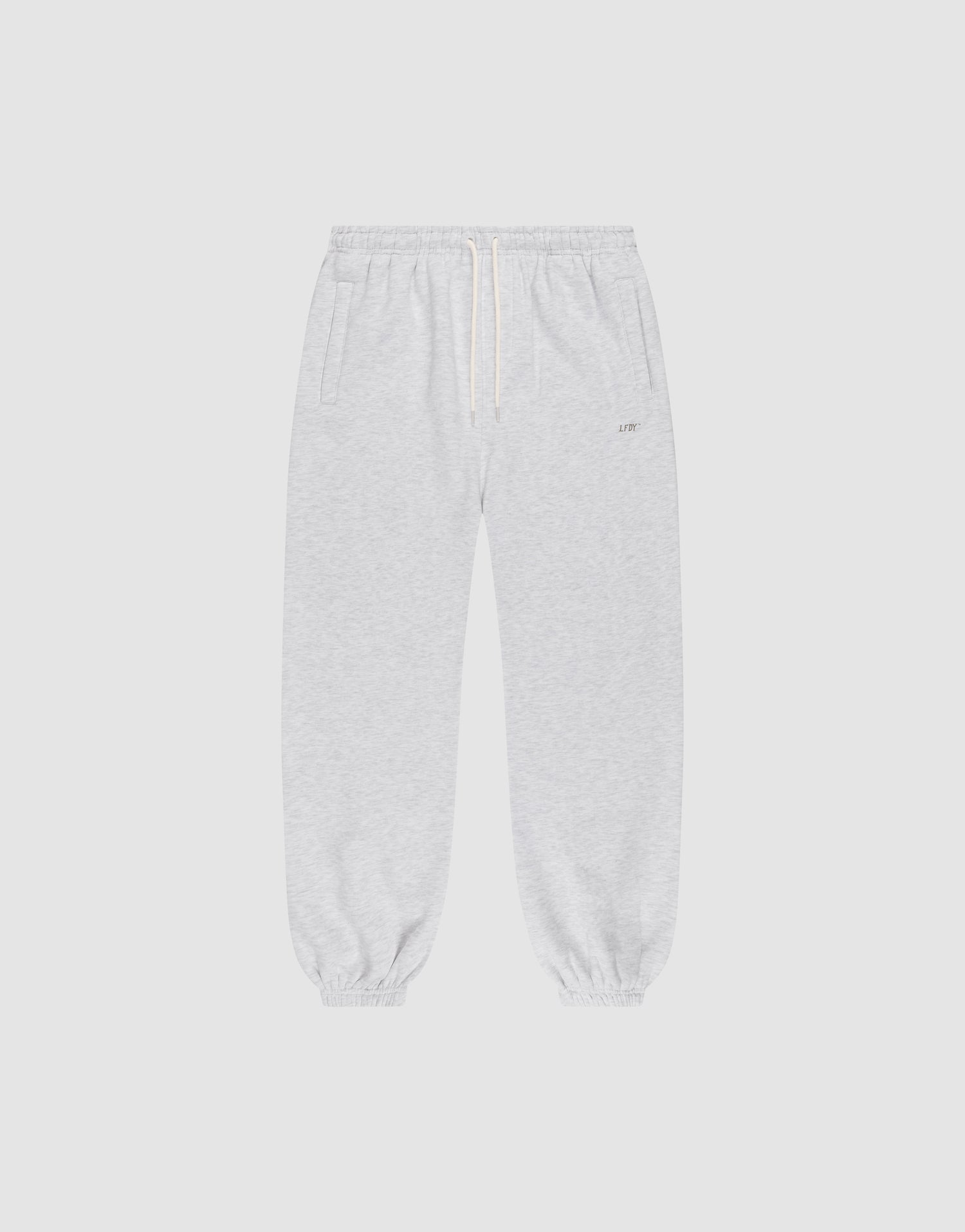 The LIVE FAST DIE YOUNG Basic Loose Jogger features light gray fabric, an Elastik-Bund waistband with white drawstring, side pockets, and elastic cuffs. The soft material and loose fit offer comfort for casual or athletic wear. | plain