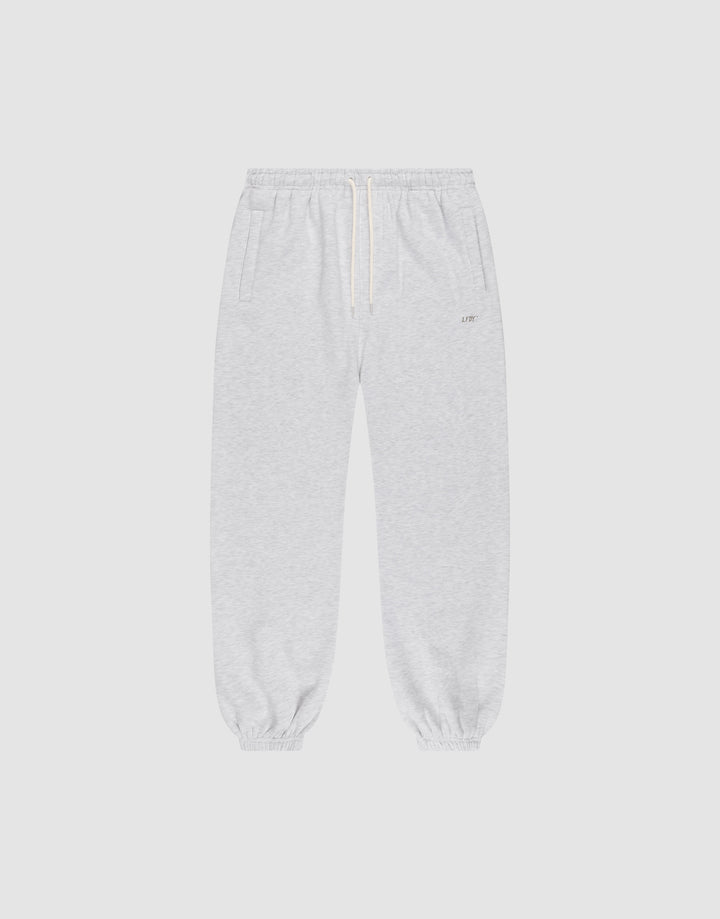 The LIVE FAST DIE YOUNG Basic Loose Jogger features light gray fabric, an Elastik-Bund waistband with white drawstring, side pockets, and elastic cuffs. The soft material and loose fit offer comfort for casual or athletic wear. | plain