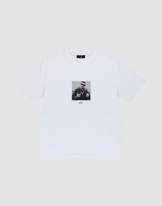 The LFDY Gambling Tee by LIVE FAST DIE YOUNG is a white regular fit t-shirt with a bold front print of a person making hand signs, sunglasses, and beanie. "LITTY" is printed below. Made from 100% Baumwolle. Displayed on a plain light background. | plain