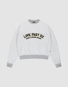 The LFDY District Sweater by LIVE FAST DIE YOUNG is a white oversized crewneck with light gray collar, cuffs, and hem in 480 GSM inside-out fabric. The chest displays bold LIVE FAST D.I.Y. text above ROAD FLECHTERIN PARADIS. | plain