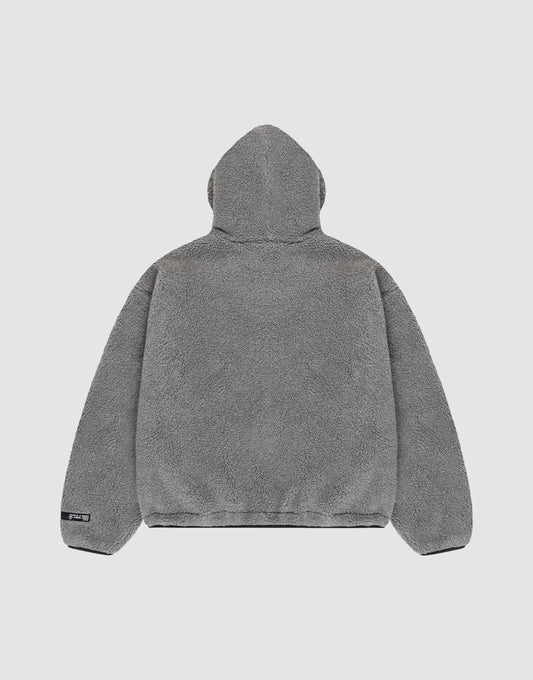The LIVE FAST DIE YOUNG LFDY Teddy Hooded jacket in gray fleece is shown from the back on a plain light background. It features a soft, plush texture, oversize fit, long sleeves, and a small black tag on the lower left hem.