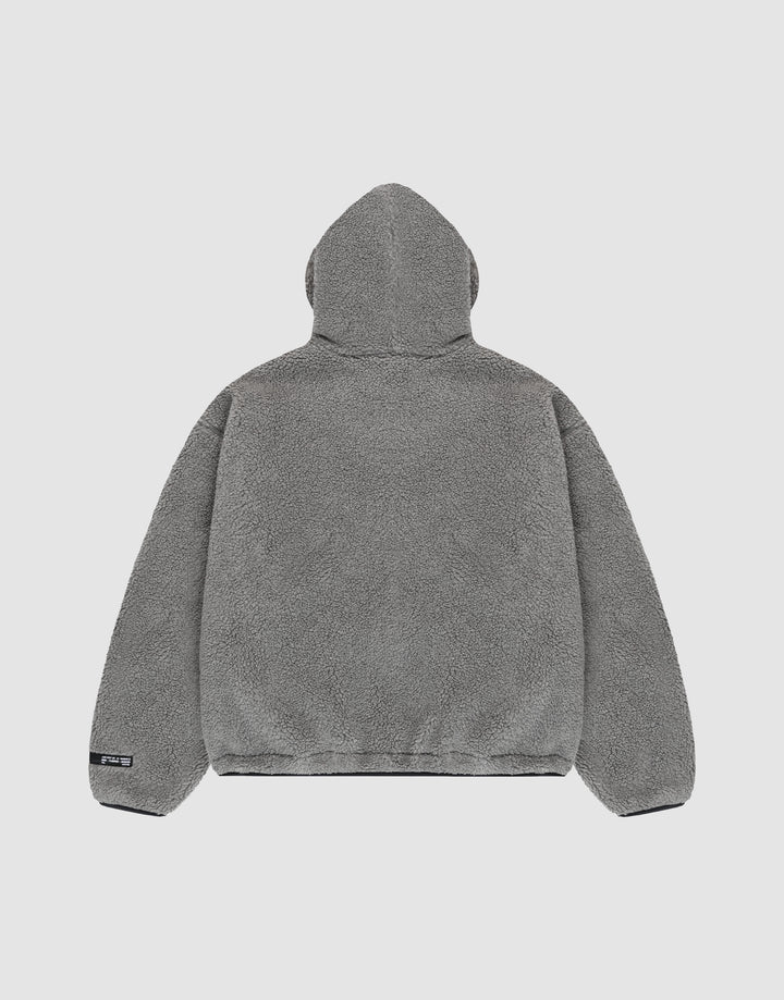 The LIVE FAST DIE YOUNG LFDY Teddy Hooded jacket in gray fleece is shown from the back on a plain light background. It features a soft, plush texture, oversize fit, long sleeves, and a small black tag on the lower left hem.