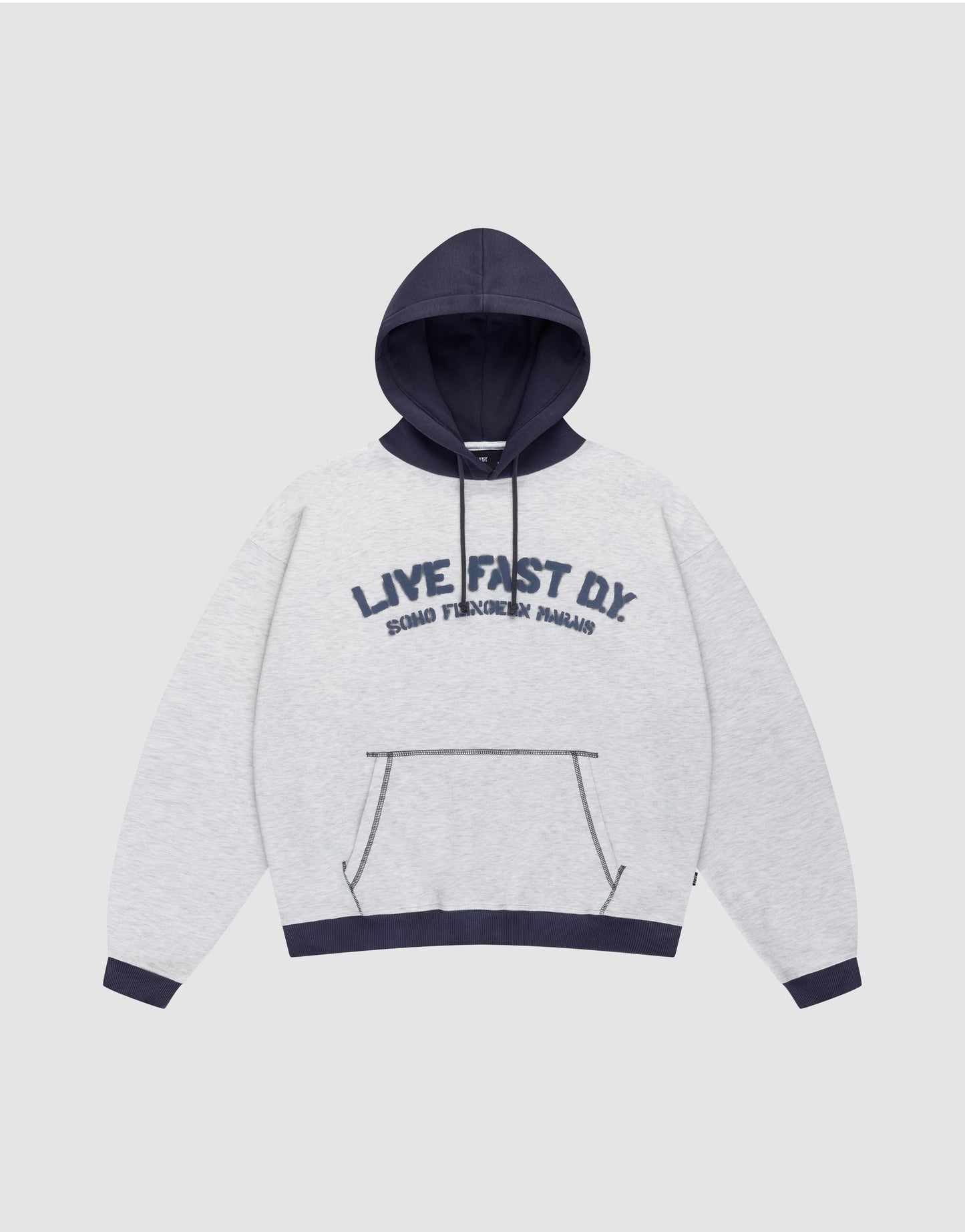 The LFDY District Hooded by LIVE FAST DIE YOUNG features a light gray oversize fit, dark blue contrast hood, cuffs, and hem. Front print: "LIVE FAST D.I.Y." with "BOARD FINGERS PALMS" below. Includes a kangaroo pocket.