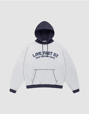 The LFDY District Hooded by LIVE FAST DIE YOUNG features a light gray oversize fit, dark blue contrast hood, cuffs, and hem. Front print: "LIVE FAST D.I.Y." with "BOARD FINGERS PALMS" below. Includes a kangaroo pocket. | plain