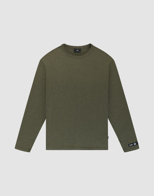The LFDY Rib Longsleeve by LIVE FAST DIE YOUNG is an oversized, olive green, plain crewneck shirt with long sleeves. It features a small black web-label tag on the left wrist and is displayed flat on a white background. | plain
