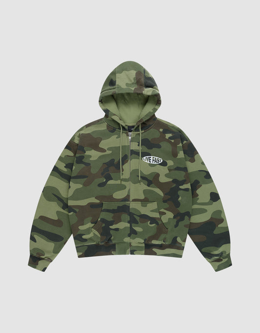 The LFDY Army Hooded Zip by LIVE FAST DIE YOUNG is an oversized green and brown camouflage zip-up hoodie with a drawstring hood, subtle vintage effect, and white "LIVE FAST" print on the left chest, shown laid flat on light gray.