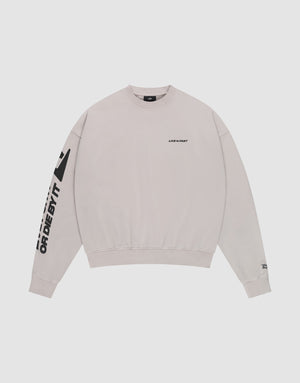 The Live For It Sweater by LIVE FAST DIE YOUNG is a light beige 100% Baumwolle crewneck with "LIVE FAST" on the chest and "OR DIE BY IT" in bold black text on the left sleeve. Features a plain white background. | plain