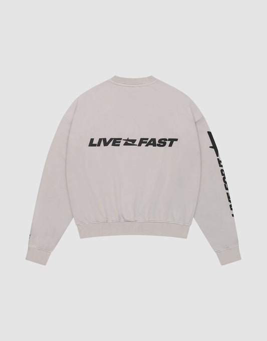 The Live For It Sweater by LIVE FAST DIE YOUNG is an oversized light gray sweatshirt, featuring “LIVE FAST” in bold black across the upper back and extra sleeve text. Made from 100% Baumwolle for comfort.