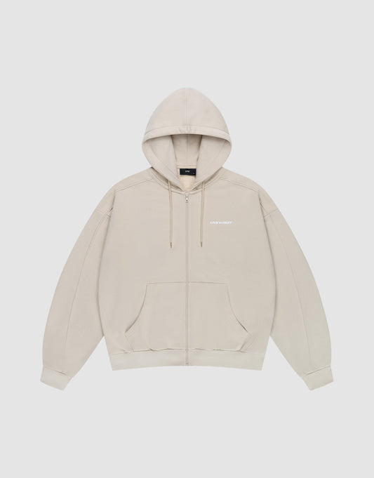 The LFDY Pleated Hooded Zip by LIVE FAST DIE YOUNG is a light beige oversized zip-up hoodie with a drawstring hood, front pockets, and small white logo on the chest. Made from 100% cotton and shown against a plain white background. | plain