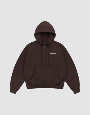 The LFDY Pleated Hooded Zip by LIVE FAST DIE YOUNG is a dark brown oversized zip-up hoodie with a drawstring hood, front pockets, and small white LIFE FAST text on the chest. Made from 100% Baumwolle. Shown on a plain light gray background. | plain