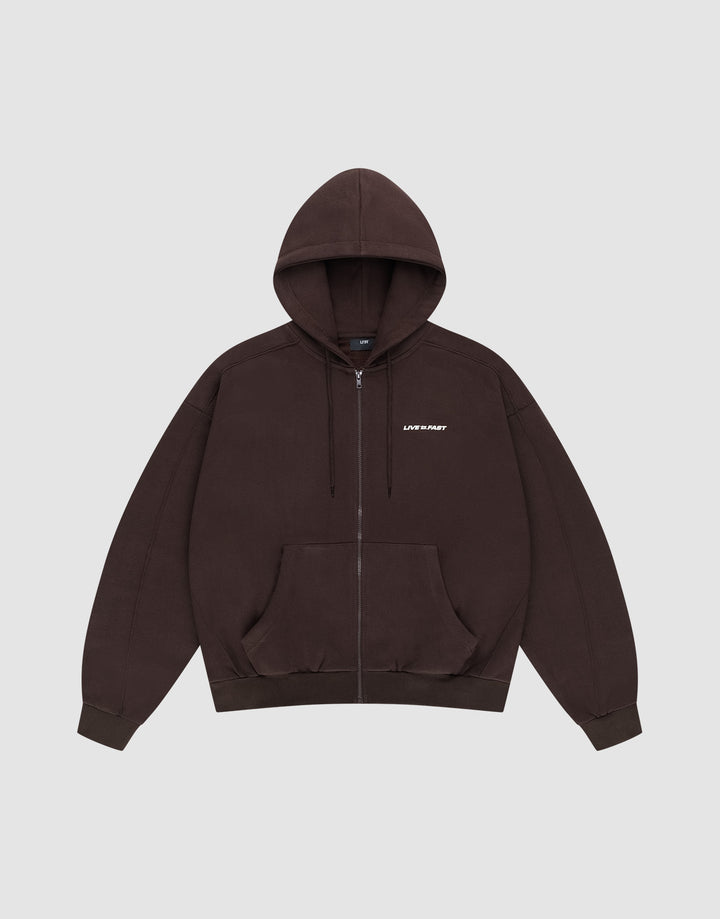 The LFDY Pleated Hooded Zip by LIVE FAST DIE YOUNG is a dark brown oversized zip-up hoodie with a drawstring hood, front pockets, and small white LIFE FAST text on the chest. Made from 100% Baumwolle. Shown on a plain light gray background. | plain