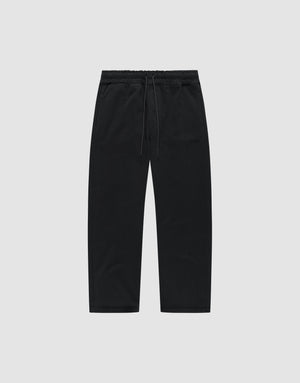 The LIVE FAST DIE YOUNG Basic Wide Jogger is a pair of black, wide-fit cotton pants with an elastic waistband and drawstring, shown flat on a light grey background. | plain