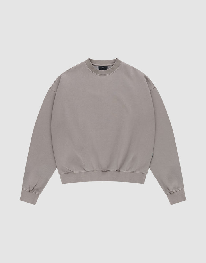 The LIVE FAST DIE YOUNG Basic Blank Sweater, a light grey vintage-washed crewneck with long sleeves, is laid flat on a white background for a classic, timeless look. | plain