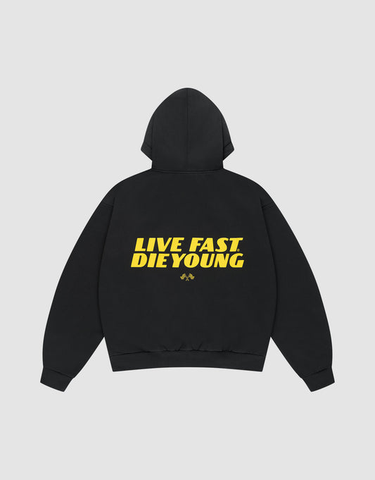 The LFDY Drift Hooded by LIVE FAST DIE YOUNG is a black oversized hoodie with a doppellagige Kapuze, bold yellow "LIVE FAST DIE YOUNG" text and a small yellow graphic on the back, made from soft Baumwolle and shown on a plain light background.