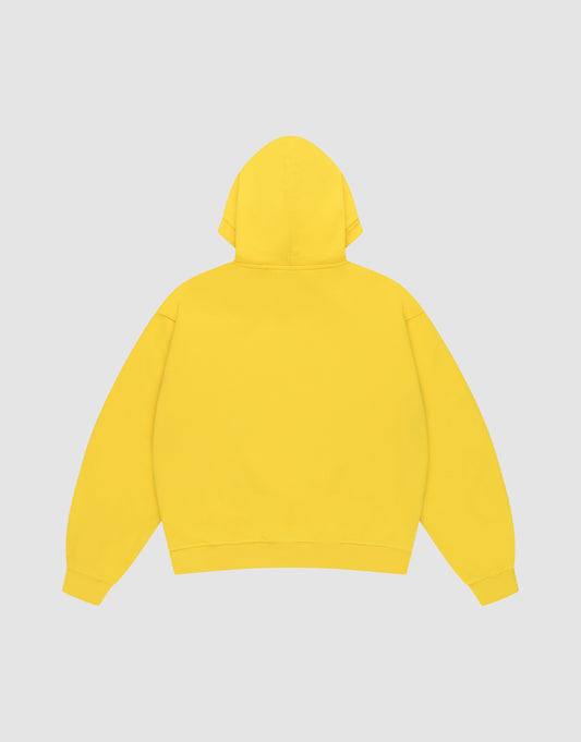 The LIVE FAST DIE YOUNG Live Fast Beware Hooded is a plain yellow oversize fit hoodie, laid flat facing backward on a light gray background. It features long sleeves, double layer 100% Baumwolle fabric, and no visible logos or designs.