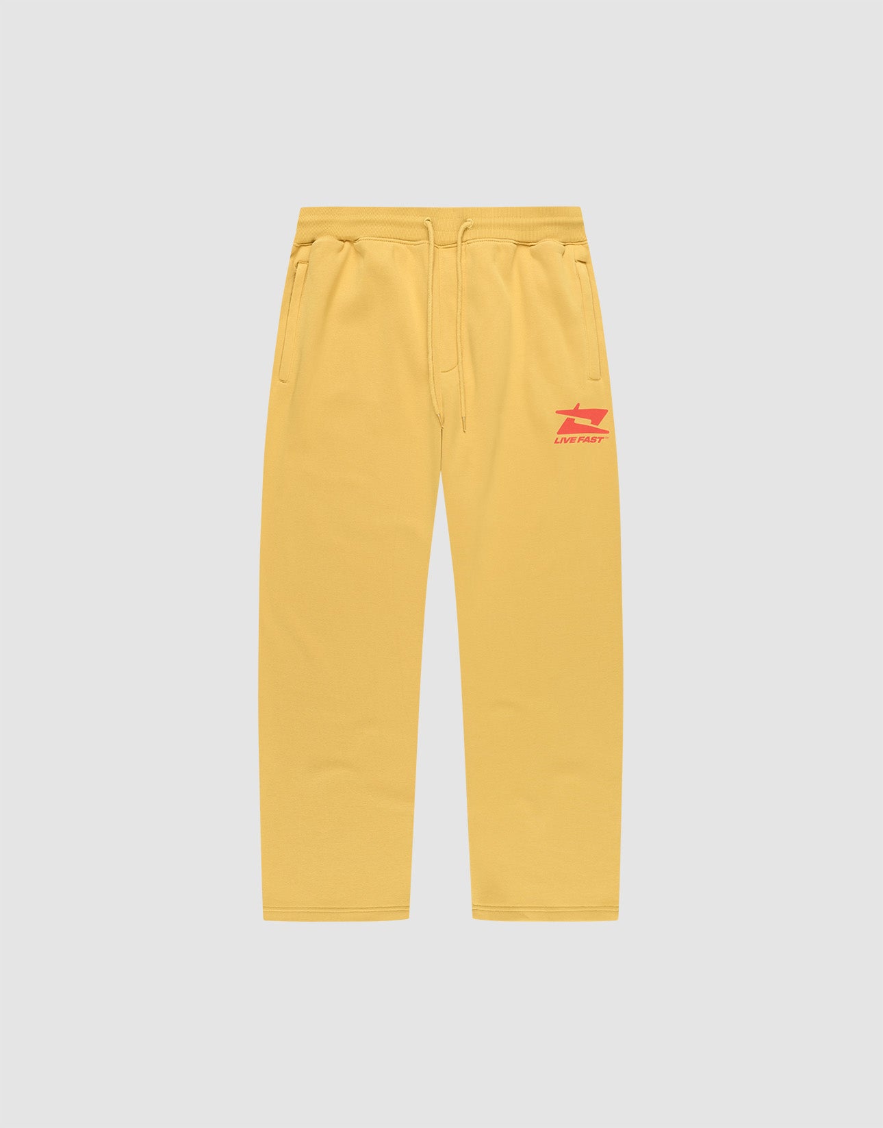The LIVE FAST DIE YOUNG Live Fast Sweatsuit Jogger features yellow wide-fit sweatpants with side pockets, an elastic drawstring waist, and red LIVE FAST text plus graphic on the left thigh, shown on a plain light grey background.