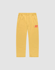 The LIVE FAST DIE YOUNG Live Fast Sweatsuit Jogger features yellow wide-fit sweatpants with side pockets, an elastic drawstring waist, and red LIVE FAST text plus graphic on the left thigh, shown on a plain light grey background. | plain