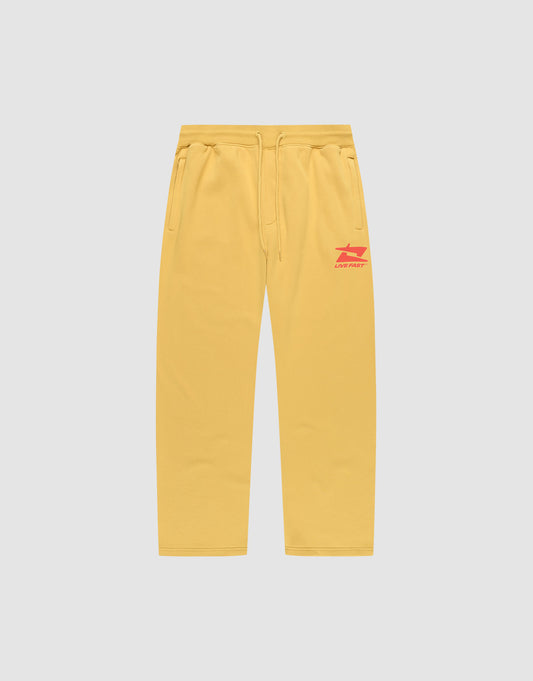The LIVE FAST DIE YOUNG Live Fast Sweatsuit Jogger features yellow wide-fit sweatpants with side pockets, an elastic drawstring waist, and red LIVE FAST text plus graphic on the left thigh, shown on a plain light grey background. | plain