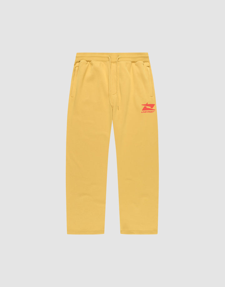 The LIVE FAST DIE YOUNG Live Fast Sweatsuit Jogger features yellow wide-fit sweatpants with side pockets, an elastic drawstring waist, and red LIVE FAST text plus graphic on the left thigh, shown on a plain light grey background. | plain