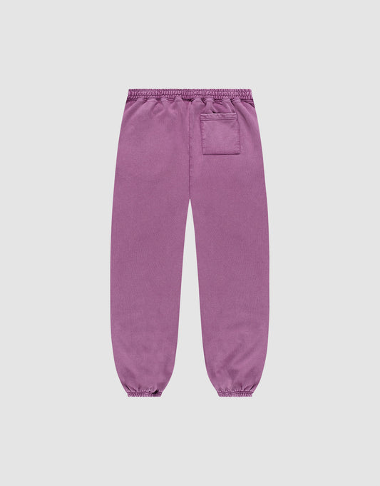 The Loyal Loose Jogger by LIVE FAST DIE YOUNG features a loose fit, elastic cuffs and waistband, single right patch pocket, and subtle vintage wash. Shown from the back in purple Baumwolle on a plain white background.