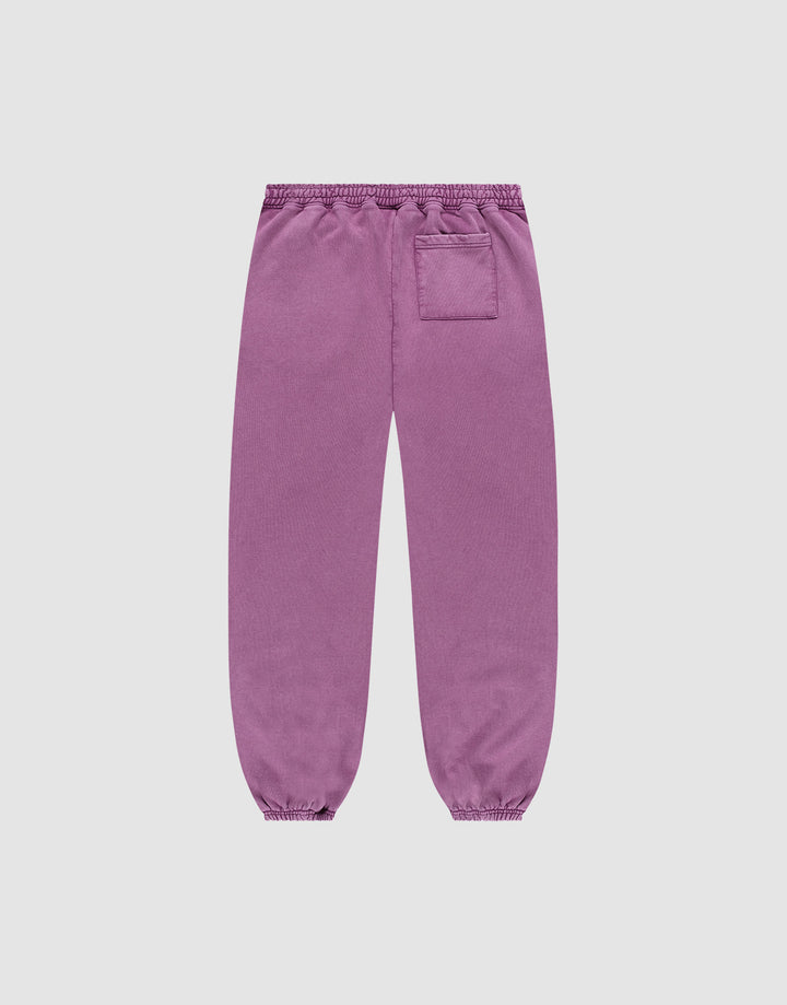 The Loyal Loose Jogger by LIVE FAST DIE YOUNG features a loose fit, elastic cuffs and waistband, single right patch pocket, and subtle vintage wash. Shown from the back in purple Baumwolle on a plain white background.