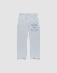 The Loyal Wide Jogger by LIVE FAST DIE YOUNG features a light grey color, Elastik-Bund waist, wide fit, and blue LIVE FAST graphic on the upper left thigh. Made from Baumwolle, shown flat on a white background. | plain