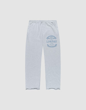 The Loyal Wide Jogger by LIVE FAST DIE YOUNG features a light grey color, Elastik-Bund waist, wide fit, and blue LIVE FAST graphic on the upper left thigh. Made from Baumwolle, shown flat on a white background. | plain