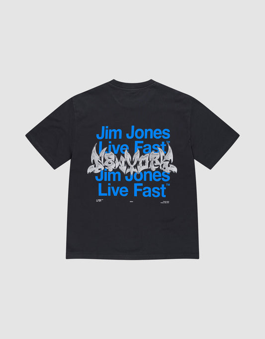 The LIVE FAST DIE YOUNG "Live Fast NY Tee" is an oversize-fit black cotton T-shirt featuring blue "Jim Jones Live Fast" text repeated twice and a white graffiti-style front print. The shirt is displayed flat on a light gray background. | plain