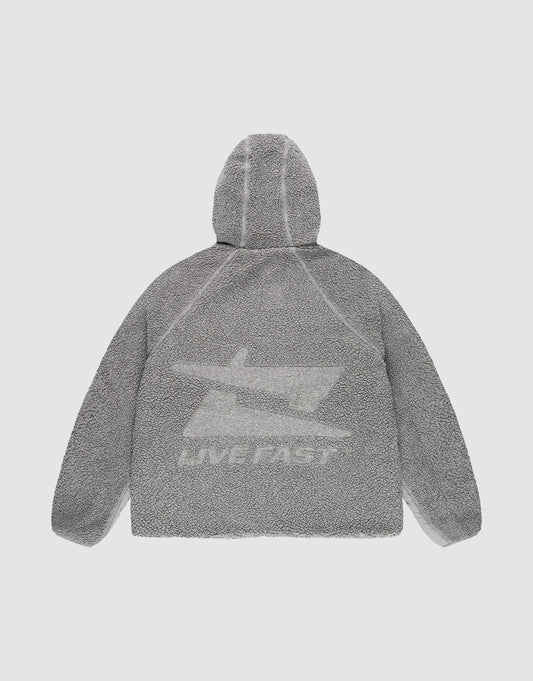 The LIVE FAST DIE YOUNG Live Fast Teddy Jacket is shown from the back in gray with a textured finish, bold jet graphic, and "LIVE FAST" in white on the lower back. Raglan sleeves complete this comfortable, standout look.
