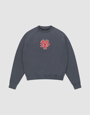 The DY Sweater by LIVE FAST DIE YOUNG is a dark gray crewneck with Raglan sleeves and a red and white abstract face graphic on the chest, shown against a plain white background. | plain