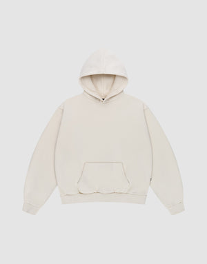 The Basic Blank Hooded by LIVE FAST DIE YOUNG is a plain, oversized off-white hooded sweatshirt with a front kangaroo pocket, ribbed cuffs, and subtle Flag-Label detail, shown flat on a light gray background. | plain