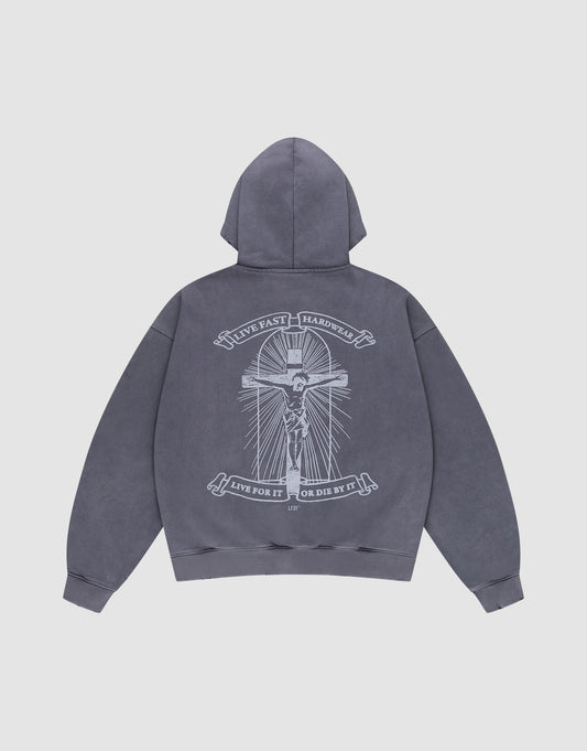 The LFDY Cross Hooded Zip by LIVE FAST DIE YOUNG is a gray oversized hoodie with a bold white skeleton-on-cross graphic, "LIVE FAST HARDWEAR" above, and banners below reading "LIVE FOR IT OR DIE BY IT," plus subtle distress details.