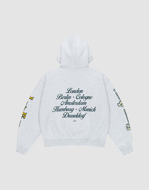 The LIVE FAST DIE YOUNG "Rhine Area Hooded" is a light gray oversized hoodie with drawstring hood, yellow and green sleeve prints, and black cursive European city names across the back. | plain