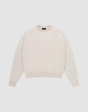 The LIVE FAST DIE YOUNG Basic Blank Sweater is a light beige, oversized crewneck with long sleeves, ribbed cuffs, hem, and collar, made from a soft cotton-polyester blend with a subtle flag label. Shown laid flat on a white background. | plain
