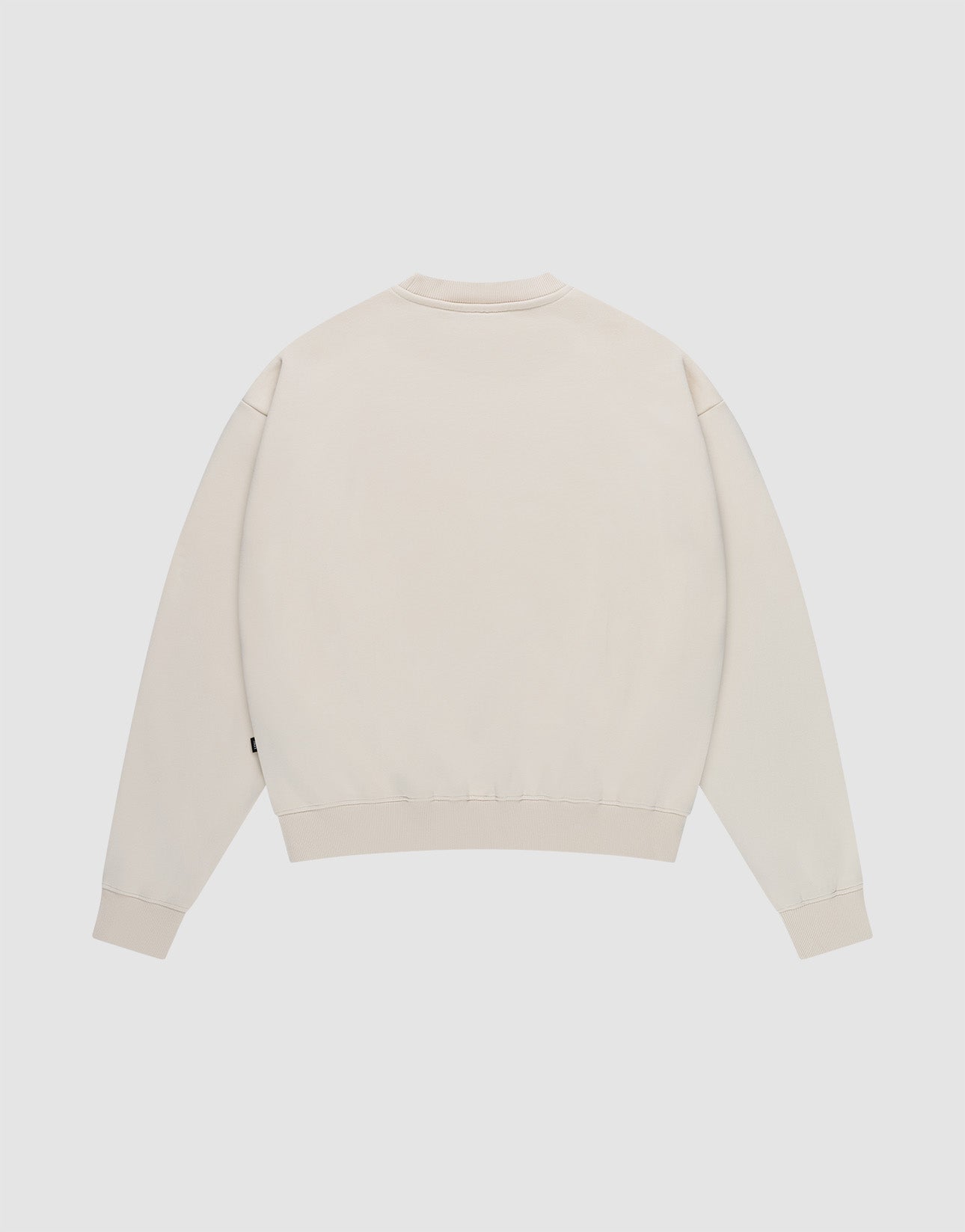 The LIVE FAST DIE YOUNG Basic Blank Sweater in light beige, featuring long sleeves and an Oversize Fit, is displayed flat with the back facing up on a white background.