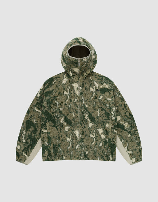 The Live Fast Teddy Jacket by LIVE FAST DIE YOUNG features a hood with visor opening, green/beige/white camouflage pattern, front zipper, and white panels on the lower sleeve sides, shown against a plain light gray background. | plain