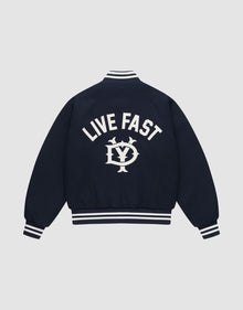 The Live Fast College Jacket by LIVE FAST DIE YOUNG is a navy varsity jacket with white striped cuffs, collar, and hem. The back features bold "LIVE FAST" Rückenstick text above an LV circular emblem. Regular fit for comfort and style. | plain