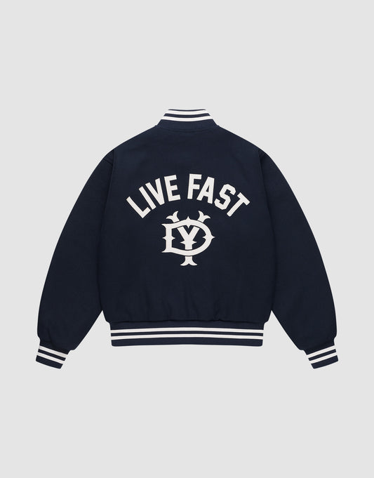 The Live Fast College Jacket by LIVE FAST DIE YOUNG is a navy varsity jacket with white striped cuffs, collar, and hem. The back features bold "LIVE FAST" Rückenstick text above an LV circular emblem. Regular fit for comfort and style. | plain