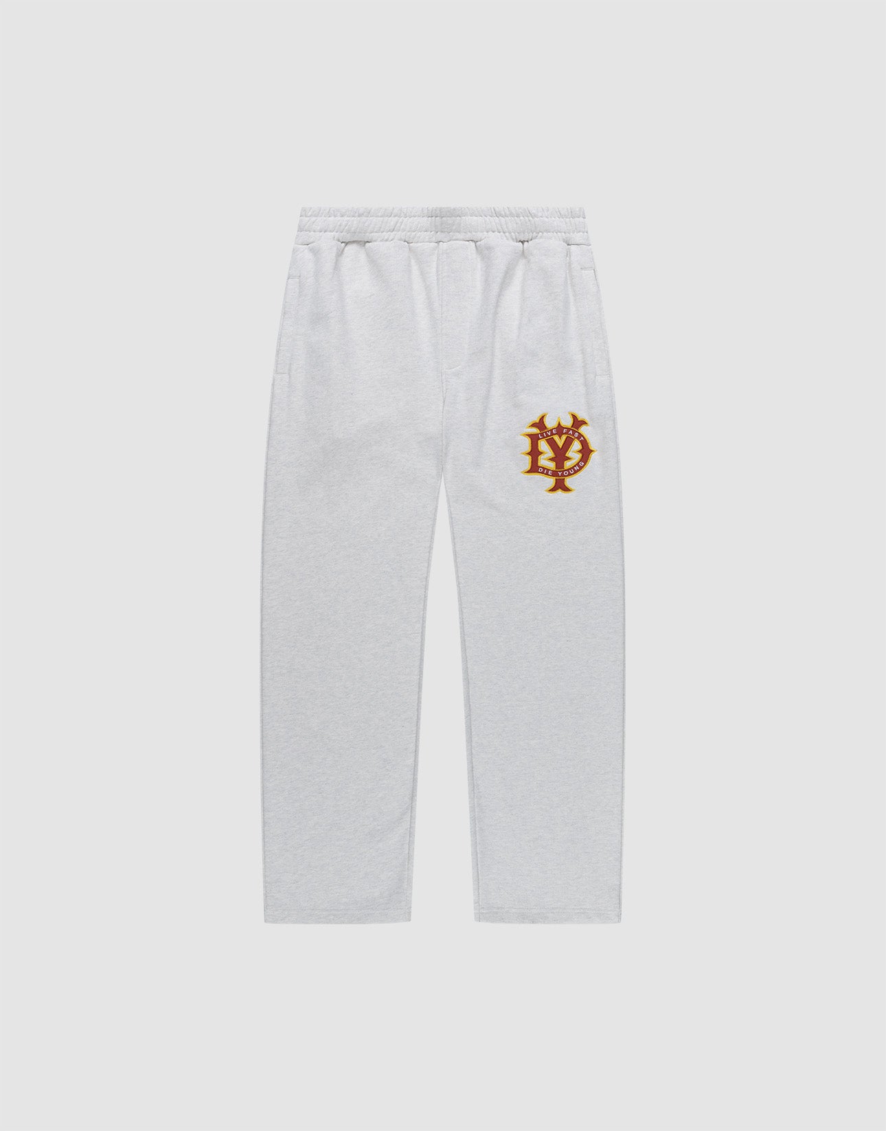 The DY Jogger by LIVE FAST DIE YOUNG features a light gray wide fit, elastic waistband, side pockets, and a gold and red crest logo on the upper left thigh. Shown against a plain white background.