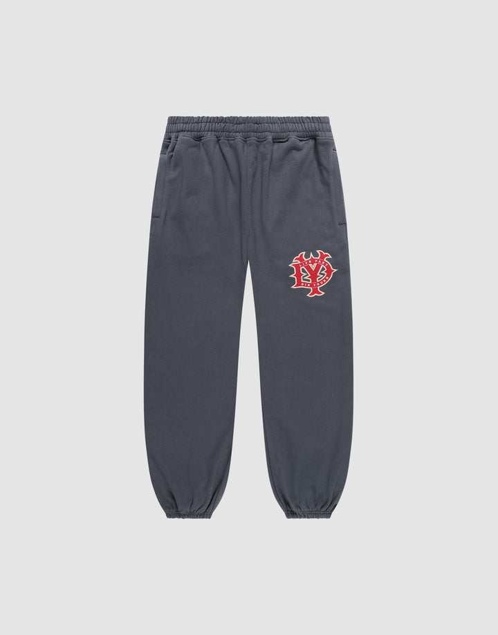 The DY Loose Jogger von LIVE FAST DIE YOUNG in Dunkelgrau ist eine locker geschnittene Sweatpants aus Baumwolle mit Elastikbund, Bündchen, Seitentaschen und rot-weißem Grafikprint am linken Oberschenkel vor hellem Hintergrund. | plain